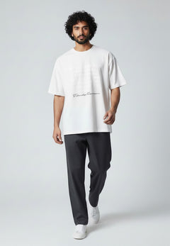 BubiniSegreti Oversized-T-Shirt in Weiß mit Front-Print, getragen von einem Model mit dunkler Hose und Sneakern