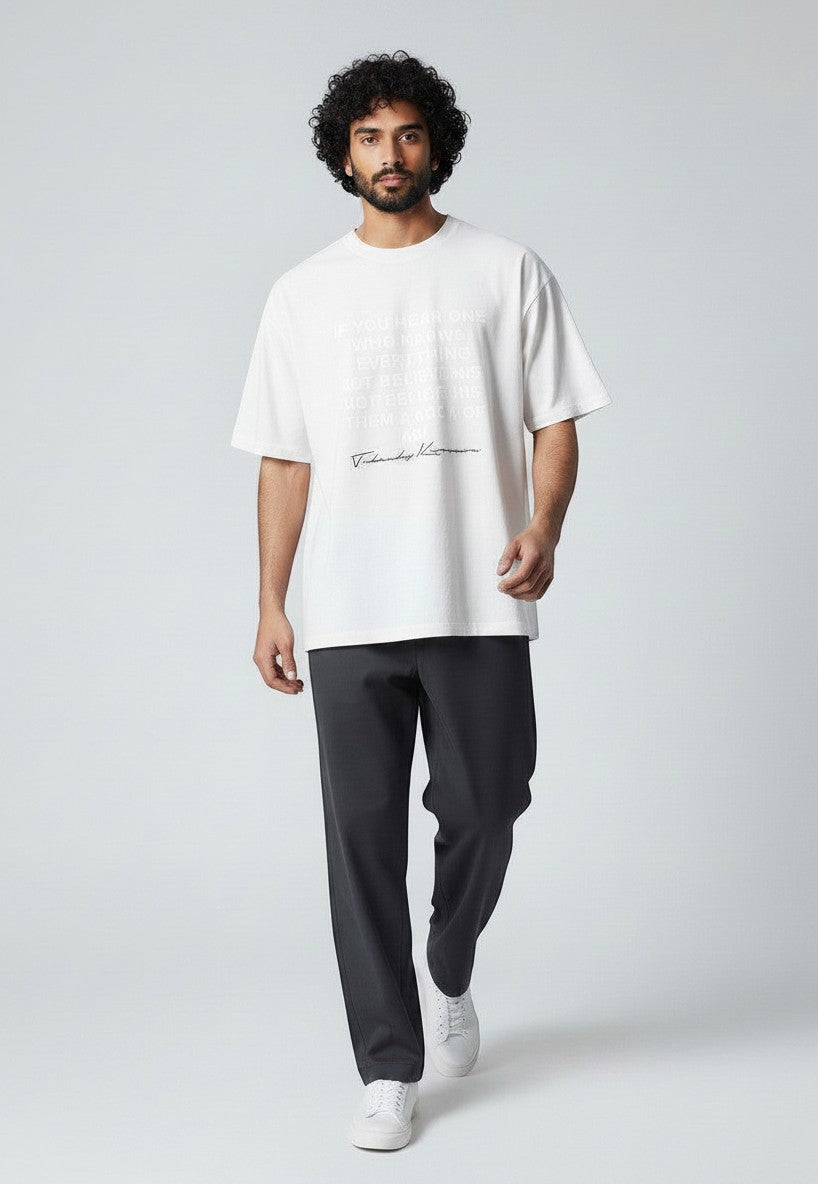 BubiniSegreti Oversized-T-Shirt in Weiß mit Front-Print, getragen von einem Model mit dunkler Hose und Sneakern
