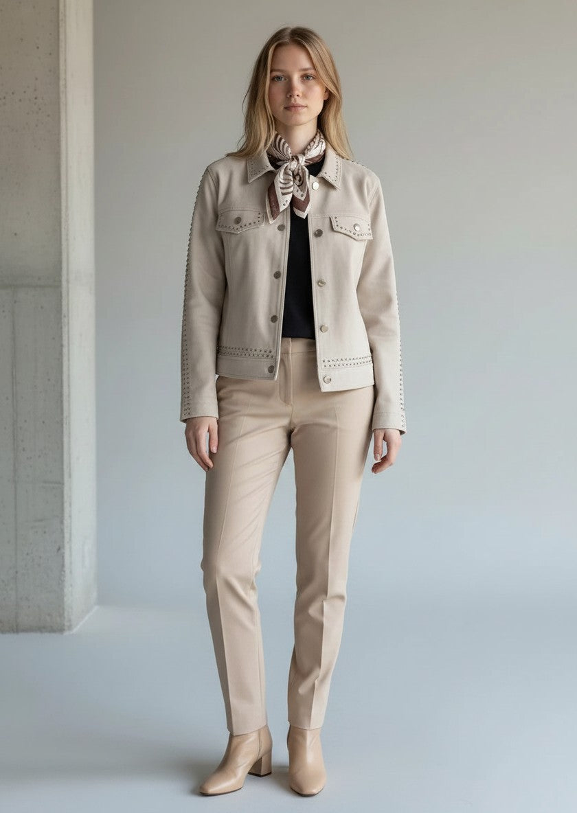 Model trägt beige BubiniSegreti Damenjacke mit Nietenverzierung und gemustertem Halstuch zu beiger Stoffhose.