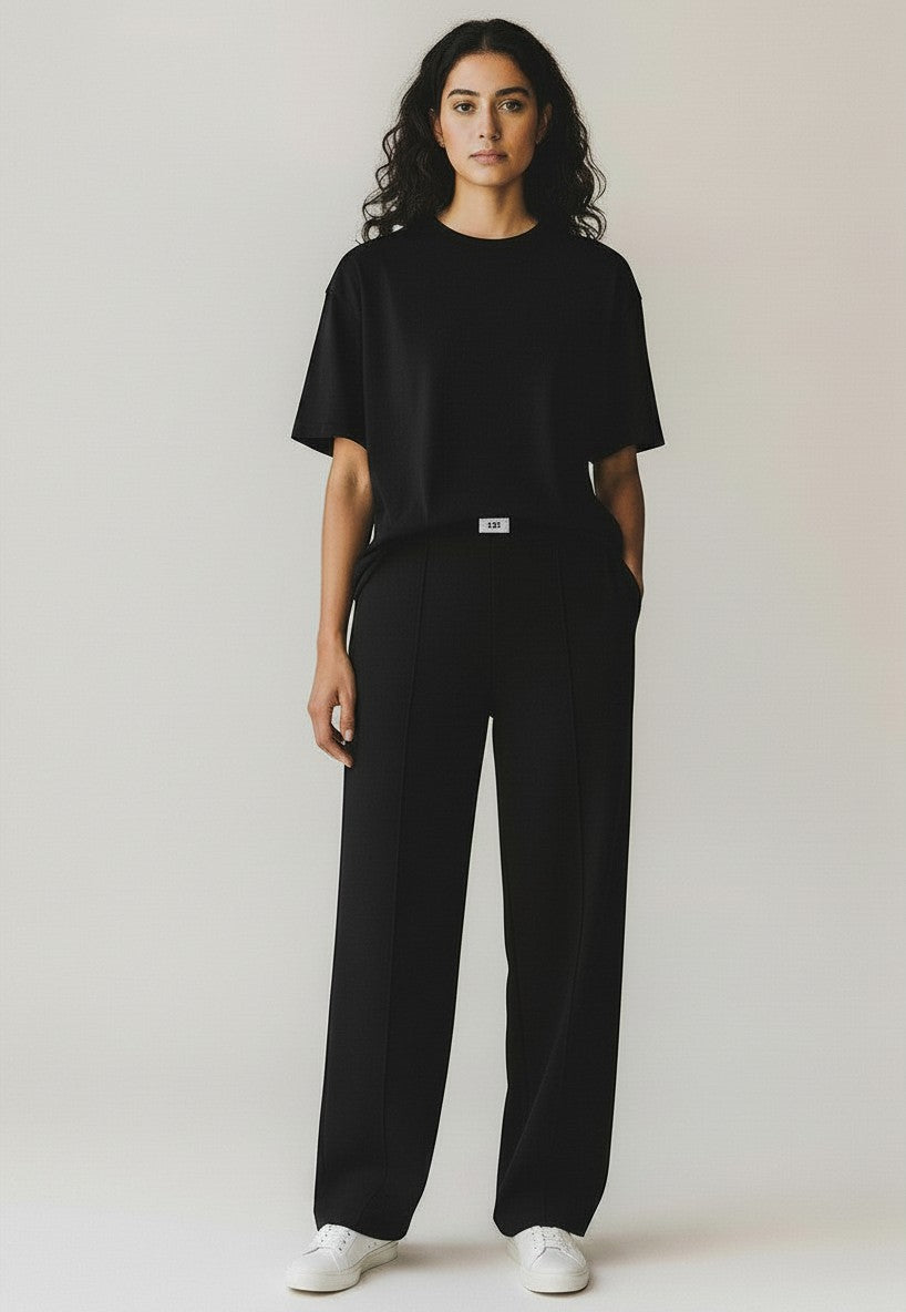 BubiniSegreti black cotton t-shirt and matching trousers set worn by a woman with white sneakers