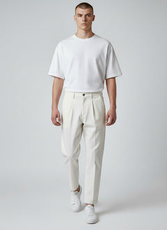 BubiniSegreti Herren-Stoffhose in Off-White mit Bundfalten aus Baumwolle, kombiniert mit weißem T-Shirt und Sneakern.