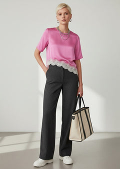 BubiniSegreti Damenbluse aus pinkem Satin mit asymmetrischem Saum und cremefarbener Spitze, kombiniert mit dunkler Hose