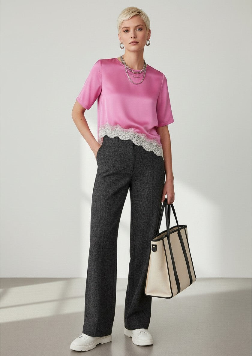 BubiniSegreti Damenbluse aus pinkem Satin mit asymmetrischem Saum und cremefarbener Spitze, kombiniert mit dunkler Hose