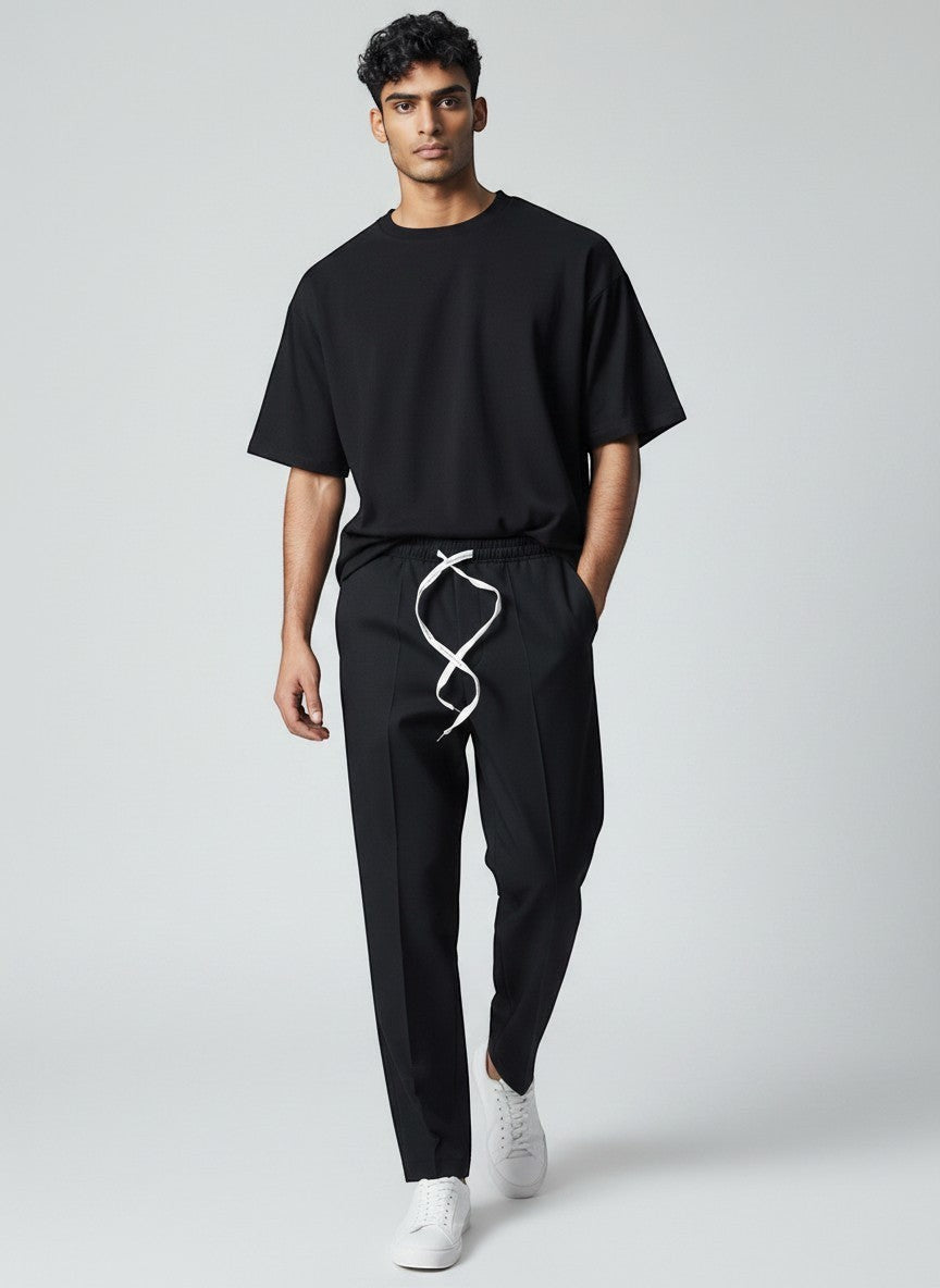 BubiniSegreti schwarze Freizeithose mit elastischem Bund und weißem Kordelzug an einem Model mit schwarzem T-Shirt