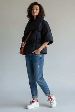BubiniSegreti gesteppte schwarze Wickeljacke mit Taillengürtel und weiten Ärmeln an einem Model mit Jeans und Sneakern
