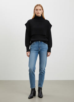 BubiniSegreti schwarzer Strickpullover mit Rollkragen, überlappender Schulterpartie und Rippbündchen an einer Frau