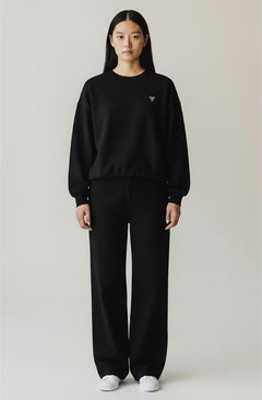 BubiniSegreti schwarzes Oversized-Sweatshirt und Hose Set mit Kordelzug und Logo-Detail an einer Frau