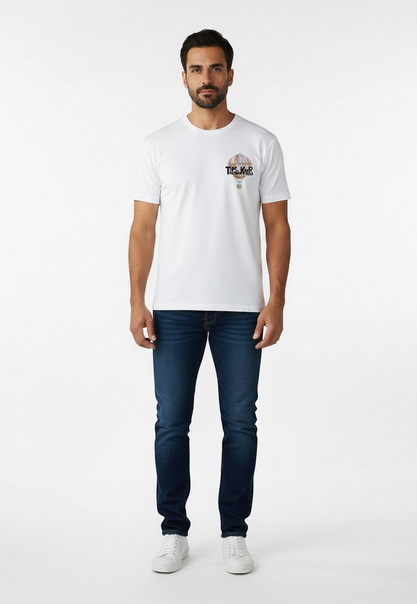 BubiniSegreti weißes Baumwoll-T-Shirt für Herren mit Heißluftballon-Print auf der Brust, getragen mit blauen Jeans.